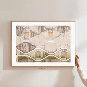 May include: A framed print featuring a detailed architectural structure with descending steps and archways. The print has a neutral color palette with beige, tan, and hints of green. The word "ORIGINS" is printed at the bottom of the frame.