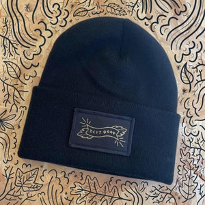 May include: Black beanie with a black patch that says "Keep Good" in gold lettering.