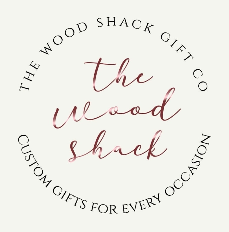 May include: The Wood Shack Gift Co. logo with the text "The Wood Shack" in a rose gold font. The text is in a circle with the words "The Wood Shack Gift Co. Custom Gifts for Every Occasion" around the outside.