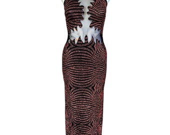 May include: A floor-length sleeveless dress featuring a black and shimmering copper-toned wavy pattern. The garment includes thin black shoulder straps and a central sheer mesh panel across the chest with a jagged, flame-like cutout design.