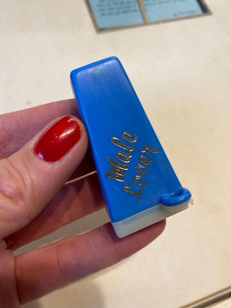 May include: A blue plastic sewing thread cutter with the words "Male Locker" printed on the side.