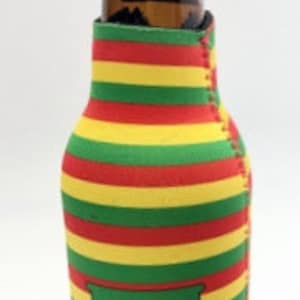 May include: A brown glass bottle inside a colorful beer can cooler. The cooler has horizontal stripes in red, yellow, and green. A green patch with a yellow leaf design is on the front of the cooler. The bottle is empty.