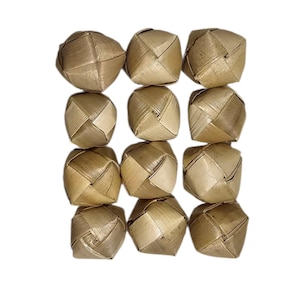 May include: A collection of twelve woven spheres, each with a geometric design. The spheres are made from a light brown, natural material, possibly dried leaves or fibers. The arrangement is symmetrical against a white background.