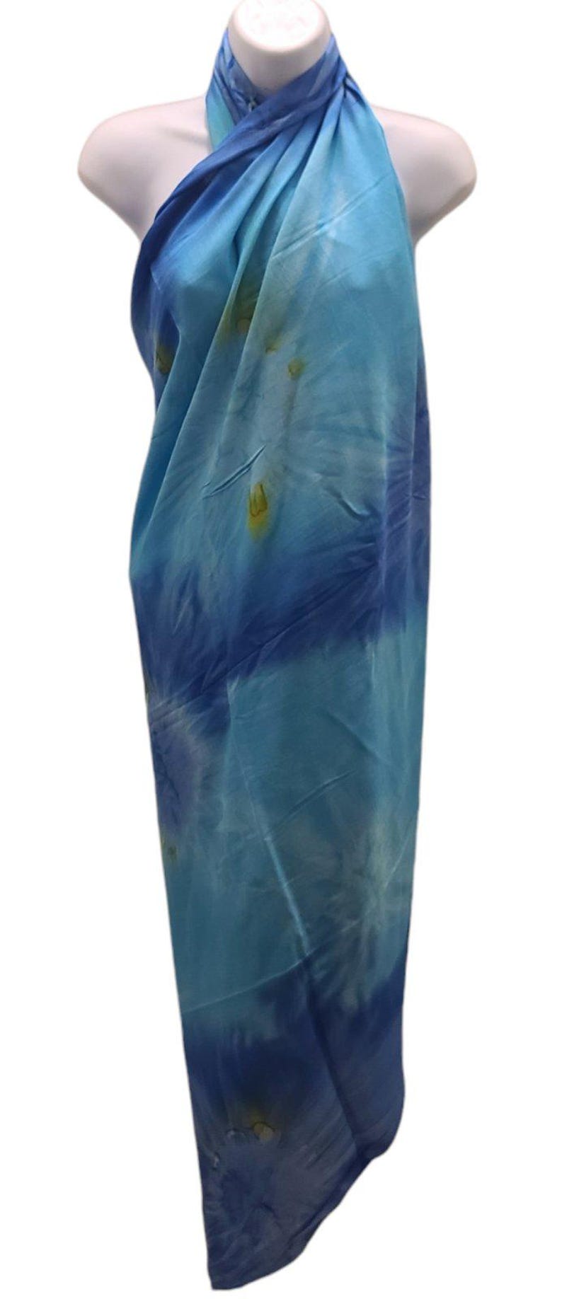 May include: A blue and white tie-dye sarong with a halter neck style. The sarong is made of a soft, lightweight fabric and is perfect for the beach or pool.