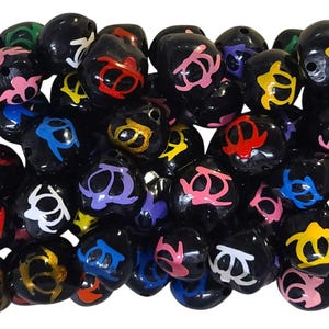 May include: A collection of black, round beads with colorful turtle designs. The beads are made of polished wood and have a glossy finish.