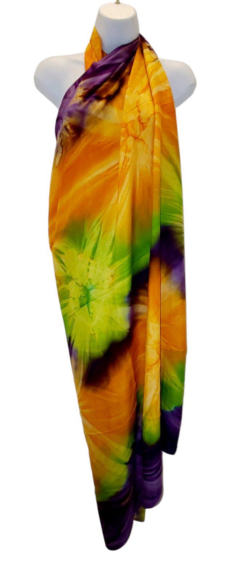 May include: A colorful sarong with a tie-dye pattern in shades of orange, green, purple, and white.