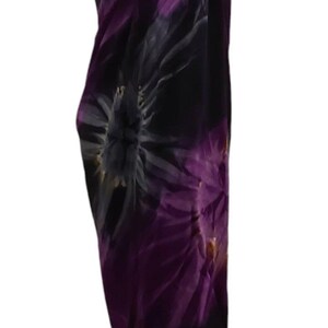 May include: A purple and gray tie-dye sarong with a floral pattern. The sarong is draped over a mannequin.
