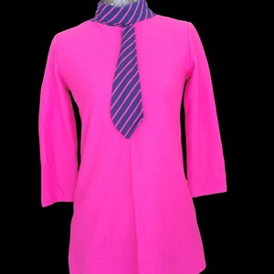 May include: A hot pink long-sleeved shirt with a mock neck and a navy blue and pink striped tie.
