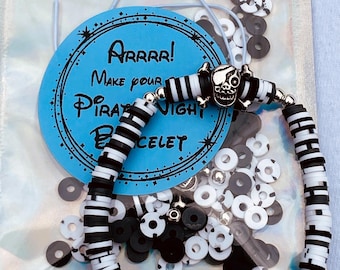 May include: A DIY pirate night bracelet kit with black and white striped beads, a skull charm, and black and white spacer beads. The kit comes in a clear plastic bag with a blue and white label that says "Arrrr! Make your Pirate Night Bracelet".