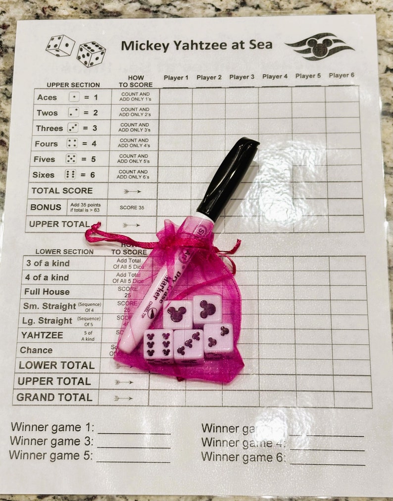 May include: Mickey Yahtzee at Sea game set. Includes a game sheet, pink dice with Mickey Mouse silhouettes, a pink marker, and a pink mesh bag. The game sheet has spaces for player scores and instructions.