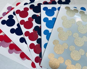 May include: Five sheets of white paper with Mickey Mouse head stickers in various colors. The stickers are glitter-covered and come in pink, red, blue, black, and gold.