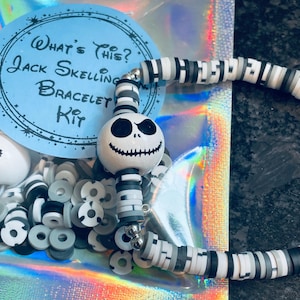 May include: A Jack Skellington bracelet kit with a white and black bead bracelet, a Jack Skellington charm, and a variety of white, black, and gray beads. The kit is packaged in a clear plastic bag with a blue and white label that says "What's This? Jack Skellington Bracelet Kit".