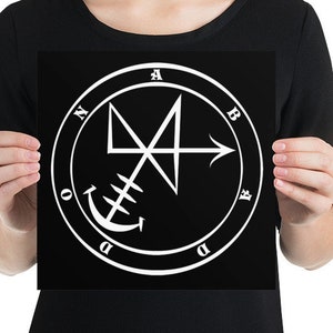 May include: A black and white print of a sigil with the letters "ABADDON" around the outside. The sigil is a white anchor with a cross and arrow.