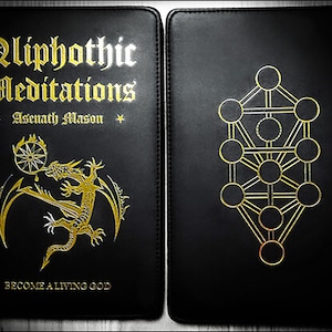 May include: A black leather-bound book with gold lettering titled "Qliphothic Meditations" by Asenath Mason. The front cover features a gold dragon with a golden wheel and a drop of blood. The back cover features a gold Tree of Life symbol.