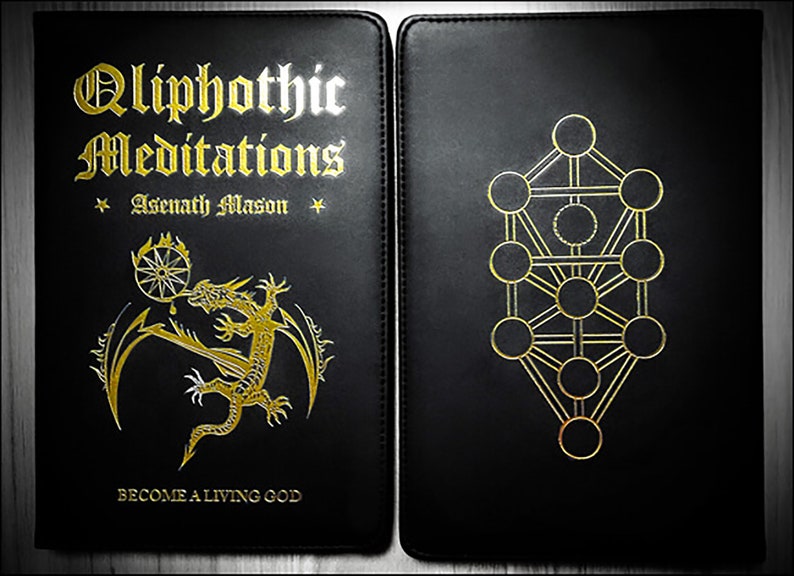 May include: A black leather-bound book with gold lettering titled "Qliphothic Meditations" by Asenath Mason. The front cover features a gold dragon with a golden wheel and a drop of blood. The back cover features a gold Tree of Life symbol.