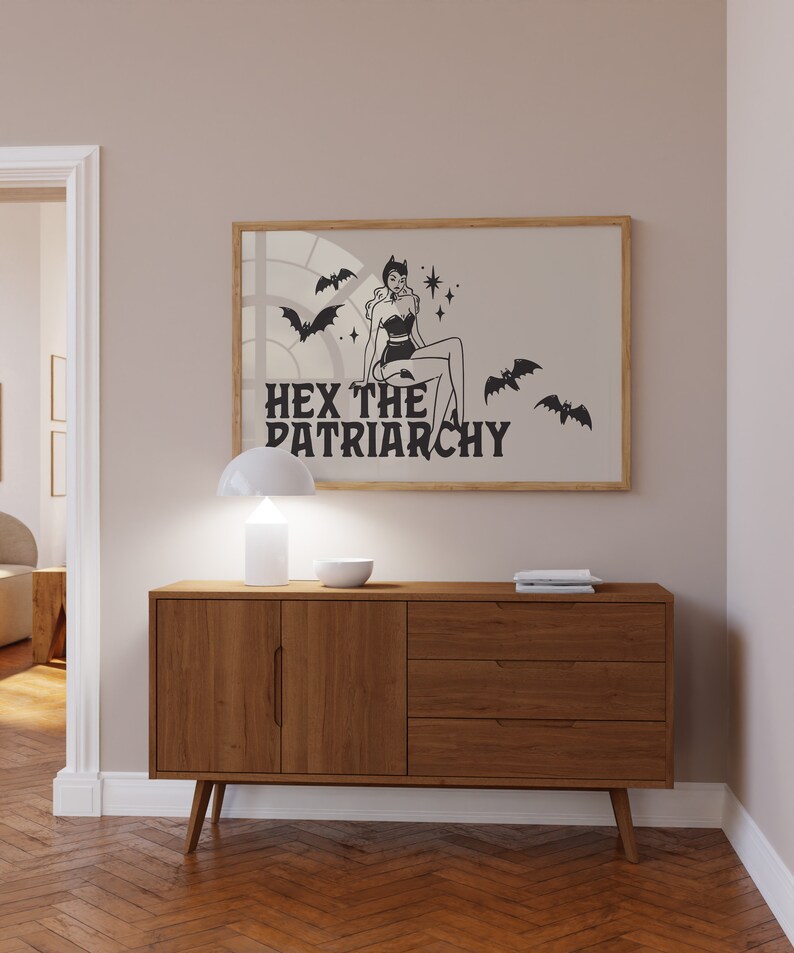 May include: A black and white illustration of a woman in a witch costume with bats and stars. The text "HEX THE PATRIARCHY" is below the image.