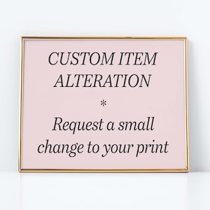 May include: A gold-framed sign with a pink background and black text that reads "CUSTOM ITEM ALTERATION * Request a small change to your print".