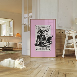 The reader tarot card print. A skeleton reading a book. Pink background, beige and black foreground. Occult witchy reading print. Perfect gift for book lovers.