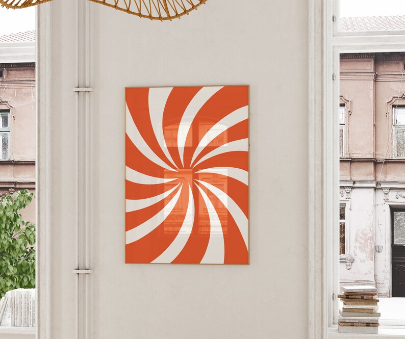 Op de afbeelding: Een ingelijste print van een rood en wit spiraalontwerp. De spiraal is gecentreerd in de lijst en heeft een witte achtergrond.