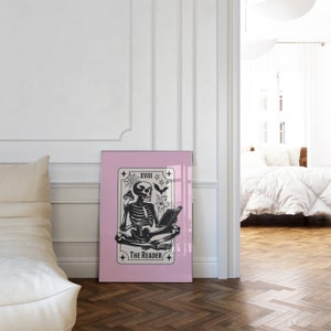 The reader tarot card print. A skeleton reading a book. Pink background, beige and black foreground. Occult witchy reading print. Perfect gift for book lovers.