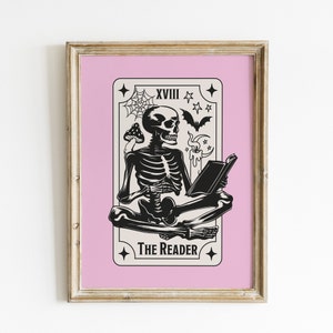 The reader tarot card print. A skeleton reading a book. Pink background, beige and black foreground. Occult witchy reading print. Perfect gift for book lovers.