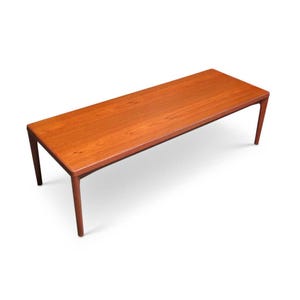 May include: A rectangular, mid-century modern coffee table. The table is made of wood with a reddish-brown finish. It has a long, flat top and four slender legs. The table is approximately 60 inches long.