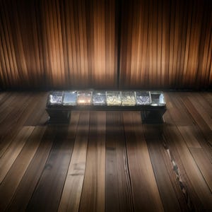 May include: A silver door handle with a clear glass insert featuring a mosaic of iridescent colors. The handle is mounted on a wooden door.