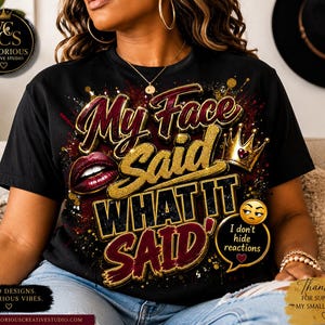Op de afbeelding: Een zwart t-shirt met een grafisch ontwerp met de tekst "My Face Said WHAT IT SAID" in goud- en bordeauxkleurige letters. Het ontwerp bevat rode lippen, een gouden kroon en een tekstballon met een emoji en de tekst "I don't hide reactions."