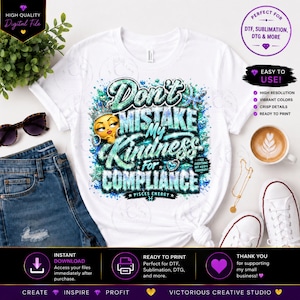 May include: A white t-shirt featuring a graphic design with the text Don't Mistake My Kindness For Compliance and Pisces Energy. The design includes a yellow emoji face wearing a crown, surrounded by teal and blue glittery accents.
