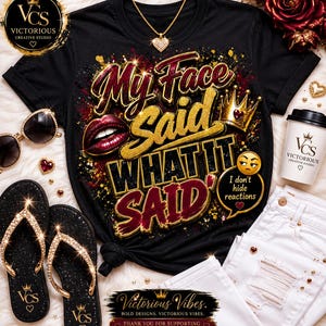 Op de afbeelding: Een zwart t-shirt met de tekst My Face Said WHAT IT SAID in goudkleurige en bordeauxrode letters, vergezeld van een afbeelding van rode lippen, een gouden kroon en een geel emoji met de tekst I don't hide reactions in een tekstballon.