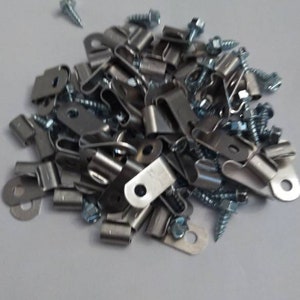 May include: A pile of silver metal picture hanging clips and screws.