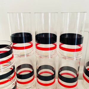 May include: Set of six clear glass tumblers with black and red stripes. The glasses are stacked in two groups of three.