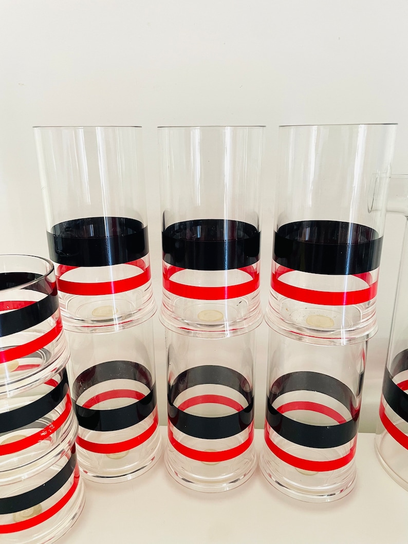 May include: Set of six clear glass tumblers with black and red stripes. The glasses are stacked in two groups of three.