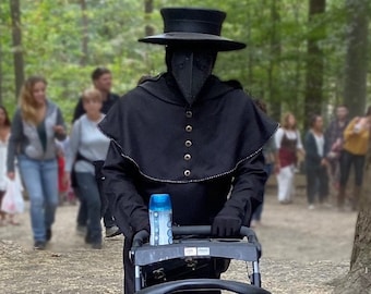 May include: A person wearing a black hooded cloak and a black mask with a long beak, pushing a black stroller with a blue water bottle in the storage basket.