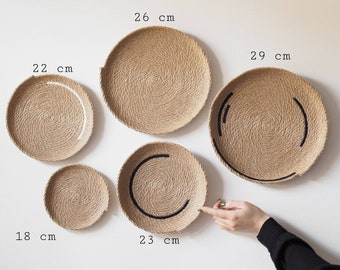 Puede incluir: Cuatro piezas de decoración de pared redonda tejidas en varios tamaños. La pieza más grande tiene 29 cm de diámetro, la siguiente más grande tiene 26 cm, la siguiente tiene 23 cm y la más pequeña tiene 18 cm. Cada pieza tiene un diseño diferente de una línea blanca o negra.