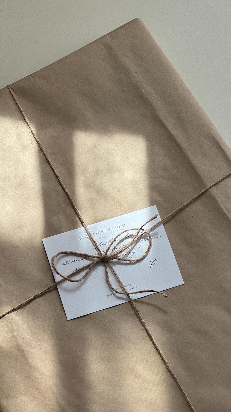 May include: A wrapped package in brown paper, tied with twine and a small white card. The card has the text "STILL LINES STUDIO" and handwritten script. The twine is tied in a bow.