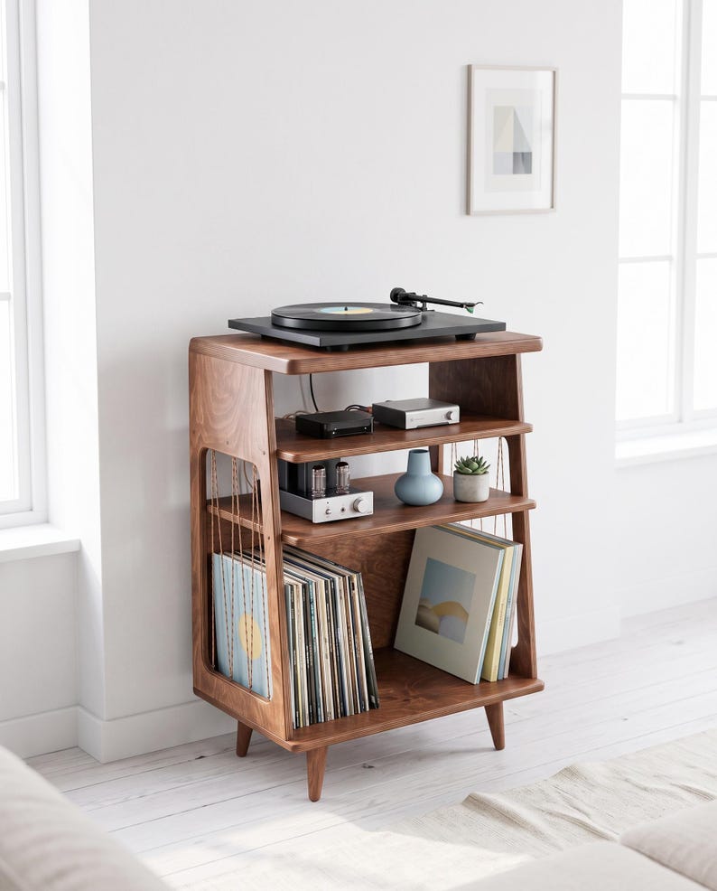 May include: A dark wood record player stand with four tapered legs, featuring a top surface for a turntable, two middle shelves for audio equipment and decor, and a bottom section for vinyl record storage with vertical side support wires.