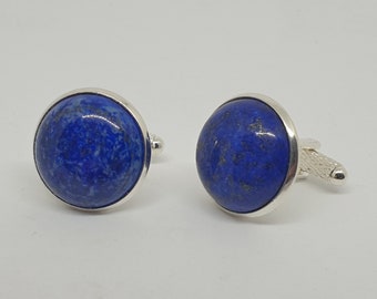 Peut inclure: Une paire de boutons de manchette avec une pierre ronde en lapis-lazuli bleu sertie dans un métal argenté.