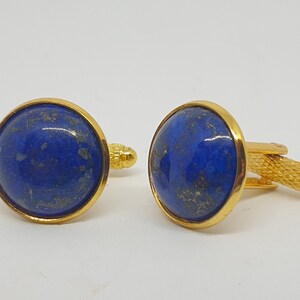 Könnte beinhalten: Ein Paar goldene Manschettenknöpfe mit blauen Lapislazuli-Steineinsätzen.