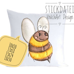 Può includere: Un cuscino bianco con un design di ape ricamato in marrone e giallo. L'ape ha un viso sorridente e sta volando. Il cuscino è disponibile nelle dimensioni 10x10 pollici, 13x18 pollici, 15x24 pollici o 18x30 pollici.