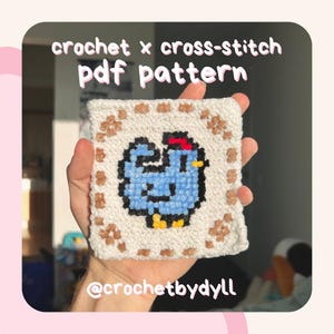 May include: A crochet and cross-stitch pattern for a blue chicken with a red comb. The pattern is framed with a brown border and is held in a hand. The text "crochet x cross-stitch pdf pattern" and "@crochetbydyll" are visible.