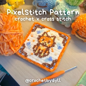 May include: A square, pixelated crochet piece featuring an orange and brown character design, surrounded by a white background and an orange border. The text "PixelStitch Pattern crochet x cross stitch" is visible. An orange crochet hook and yarn ball are also present.