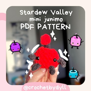 Puede incluir: Un juguete de peluche Junimo de Stardew Valley de color rojo tejido a crochet con brazos y piernas negros. El Junimo está sosteniendo una pequeña fruta morada. La imagen incluye el texto "Stardew Valley mini Junimo PDF PATTERN" y "@crochetbydyll".
