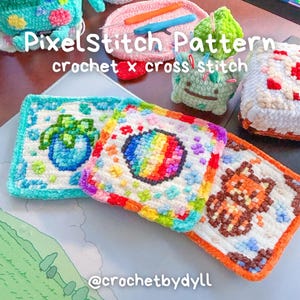 Könnte beinhalten: Drei quadratische Häkeluntersetzer mit pixeligen Motiven einer blauen Pflanze, eines Regenbogenkreises und eines orangefarbenen Tieres. Der Text PixelStitch Pattern crochet x cross stitch und @crochetbydyll ist neben einer grünen Figur sichtbar.
