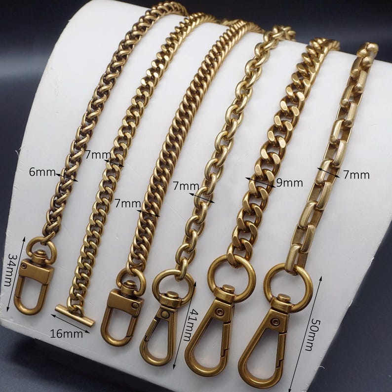 K&ouml;nnte beinhalten: F&uuml;nf goldfarbene Metallkettenriemen in verschiedenen Stilen und L&auml;ngen. Die Ketten haben unterschiedliche Gliederdesigns, mit Messungen in Millimetern. Jede Kette hat einen Verschluss oder Verbinder am Ende.