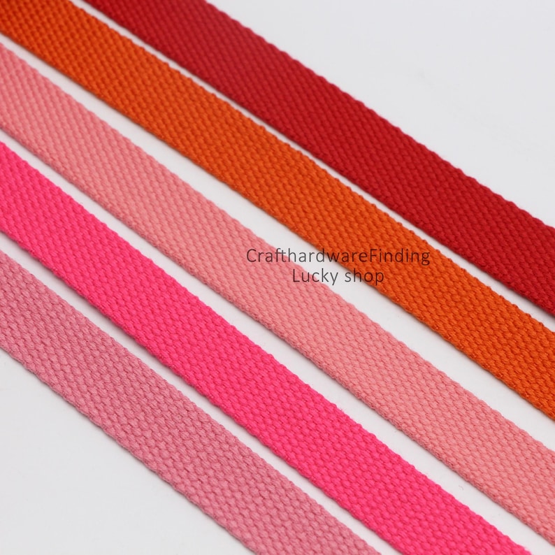 Pu&ograve; includere: Cinque nastri in tessuto di cotone di diversi colori. I nastri sono disposti in un gradiente dal rosso al rosa. I nastri hanno tutti la stessa larghezza e sono realizzati in tessuto intrecciato. Il testo "CrafthardwareFinding Lucky shop" &egrave; visibile nell'immagine.