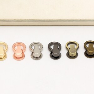 May include: Five metal ring closures in different finishes: gold, rose gold, silver, gunmetal, and antique brass.