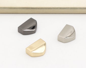 May include: Three half-circle metal hardware pieces in gold, silver, and black.