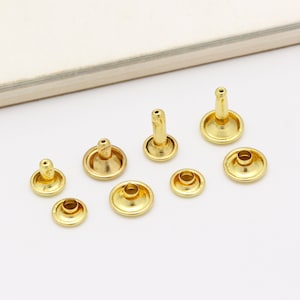 Peut inclure: Assortiment de rivets en métal doré de différentes tailles et formes. Les rivets ont une tête plate et un axe qui peut être martelé en place.