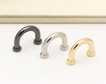 May include: Three metal D-ring hardware pieces in black, silver, and gold.